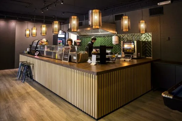 Moderne horecabalie met houten afwerking en sfeerverlichting in Markerkant 13.